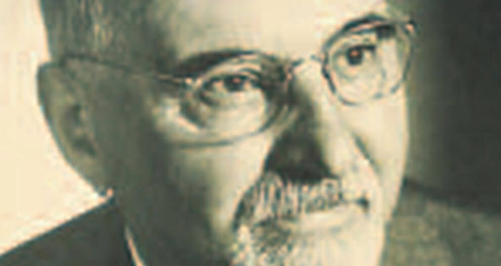 A close-up of a man's face, showing his eyes, nose, and mouth, with a beard and mustache, wearing glasses.