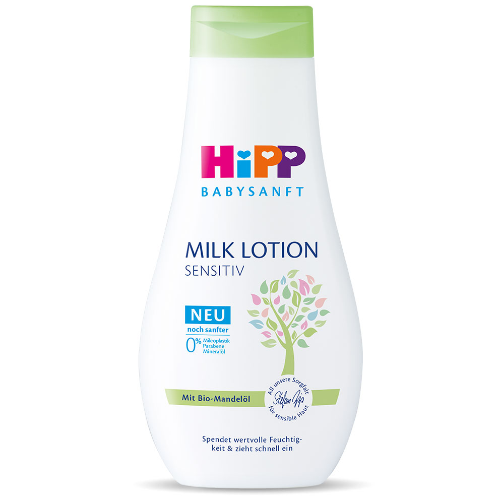 Bela steklenička z zelenim pokrovčkom z napisom "Hipp Babysanft Milk Lotion SENSITIV" vsebuje grafiko drevesa in nemško besedilo.