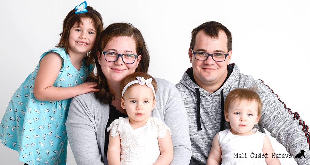 Petčlanska družina, ki jo sestavljajo dva odrasla in trije otroci, pozira za portret.