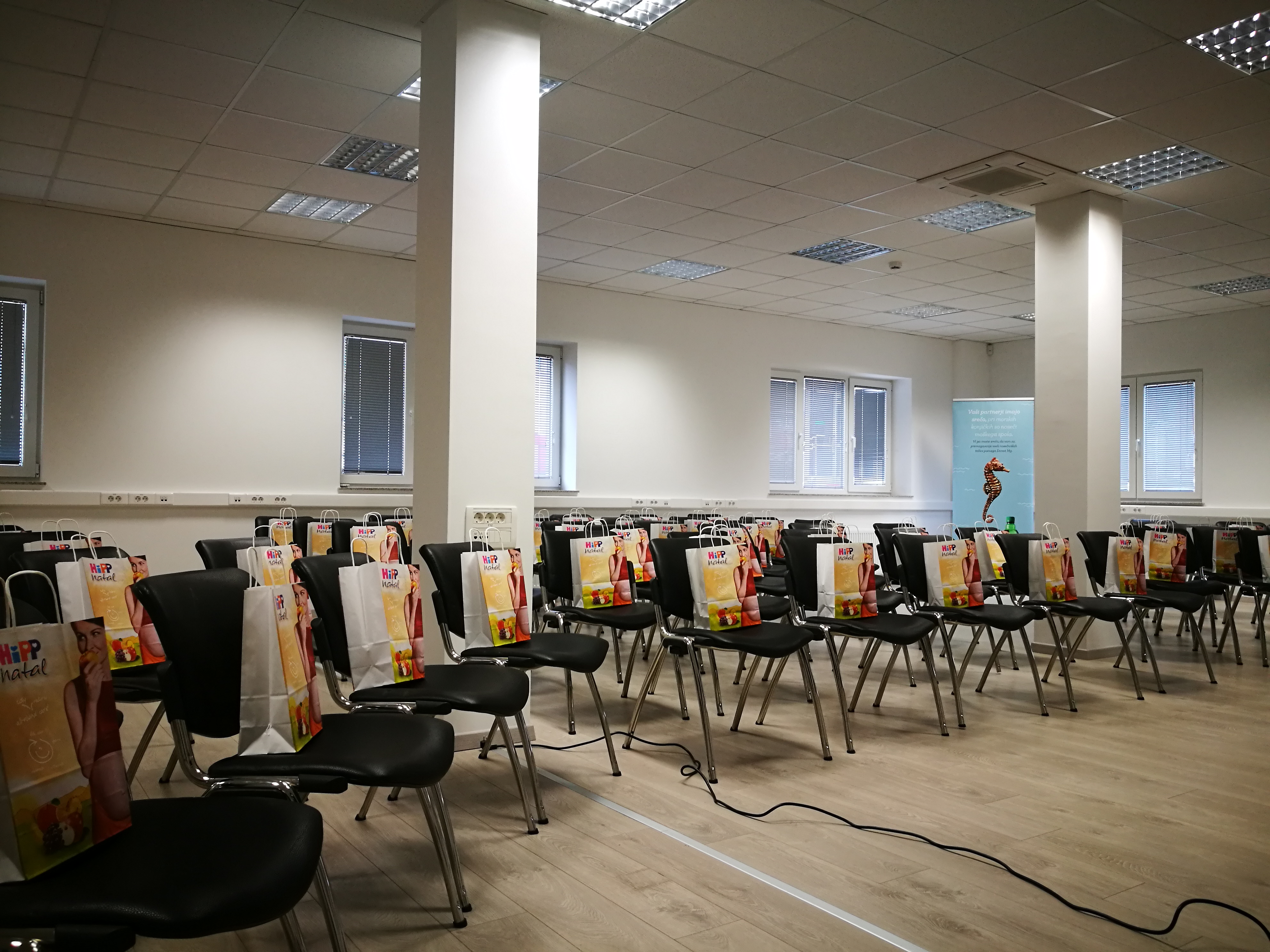 Konferenčna soba s stoli in vrečkami na njih.